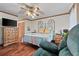 Bedroom with wooden floors, ceiling fan, and windows bringing in natural light at 110 The Farm Rd, Mcdonough, GA 30252