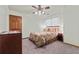 A bright bedroom features neutral walls, a patterned quilt, a ceiling fan, and a carpeted floor at 110 The Farm Rd, Mcdonough, GA 30252