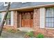 Close-up view of a stylish front door with decorative glass inserts, flanked by sidelights and white shutters at 110 The Farm Rd, Mcdonough, GA 30252