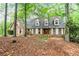 Charming brick home featuring a symmetrical facade, dormer windows, and lush surrounding greenery at 110 The Farm Rd, Mcdonough, GA 30252