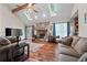 Cozy living room featuring a stone fireplace, high ceilings with skylights, and hardwood floors at 110 The Farm Rd, Mcdonough, GA 30252