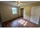 Bedroom features a window, wood laminate floors, closet and paint ready for a new design at 4009 Ester Sw Dr, Atlanta, GA 30331