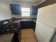 Kitchen area showcasing a gas range, refrigerator, sink, and dark cabinetry at 4009 Ester Sw Dr, Atlanta, GA 30331