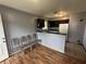 An eat-in kitchen featuring wood flooring, a refrigerator, and dark cabinets at 4009 Ester Sw Dr, Atlanta, GA 30331
