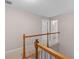 A view of the upstairs hallway with a wooden banister and neutral colored walls leading to other rooms at 445 Royal St, Mcdonough, GA 30253