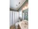 Clean bathroom with a single sink vanity, shower with curtain, and tile floors at 6084 Queens River Dr, Mableton, GA 30126