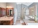 Well-lit bathroom featuring a glass-enclosed shower, a soaking tub, and a stylish vanity at 6084 Queens River Dr, Mableton, GA 30126