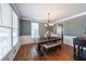 Traditional dining room with hardwood floors, large windows, and a decorative chandelier creates an inviting space at 6084 Queens River Dr, Mableton, GA 30126