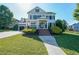 Inviting two-story home with a classic white facade, covered porch, manicured lawn, and charming landscaping at 6084 Queens River Dr, Mableton, GA 30126