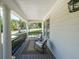 Relaxing covered porch featuring comfortable seating, classic columns, and a view of the serene neighborhood at 6084 Queens River Dr, Mableton, GA 30126
