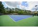 Community tennis courts are surrounded by tall trees and lush landscaping at 6084 Queens River Dr, Mableton, GA 30126