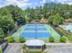 An aerial view showcases tennis courts surrounded by lush greenery and landscaping at 6084 Queens River Dr, Mableton, GA 30126
