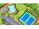 Aerial view showcasing the community pool, tennis courts, parking, and lush landscaping of the property at 9270 Colham Dr, Cumming, GA 30041
