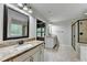 Bright bathroom featuring granite counters, modern fixtures, tiled floors, and a glass enclosed shower at 9270 Colham Dr, Cumming, GA 30041