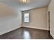 Empty bedroom featuring one window and dark wood flooring at 9270 Colham Dr, Cumming, GA 30041
