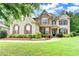 Inviting brick two story home with manicured lawn and beautiful, colorful landscaping at 9270 Colham Dr, Cumming, GA 30041