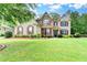 Inviting brick two story home with manicured lawn and beautiful, colorful landscaping at 9270 Colham Dr, Cumming, GA 30041