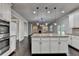 Open kitchen with a granite center island and stainless appliances offering seamless flow into the living area at 9270 Colham Dr, Cumming, GA 30041