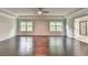 Large primary bedroom with hardwood floors, tray ceiling, and natural lighting at 9270 Colham Dr, Cumming, GA 30041
