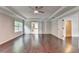 Spacious primary bedroom with hardwood floors, a tray ceiling, and natural light at 9270 Colham Dr, Cumming, GA 30041