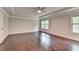 Primary bedroom featuring hardwood floors, tray ceiling, and plenty of light at 9270 Colham Dr, Cumming, GA 30041