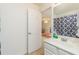 A serene bathroom with a white vanity and a glimpse into the bonus room, offering a seamless transition at 2623 Grapevine Cir # 602, Cumming, GA 30041