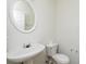 Small bathroom featuring a toilet, sink, and a round mirror at 312 Burdock Trce, Woodstock, GA 30188