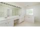 Bathroom featuring double sink vanity, large mirror, a window, and bathtub at 312 Burdock Trce, Woodstock, GA 30188
