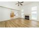 Open living room with hardwood floors and a fireplace, connecting to the kitchen at 312 Burdock Trce, Woodstock, GA 30188