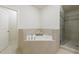 Bathroom featuring a tiled corner bathtub and a glass-enclosed shower at 5260 Cresslyn Rdg, Alpharetta, GA 30005