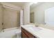Bright bathroom featuring a shower with a tile surround, wood vanity, and modern sink at 5260 Cresslyn Rdg, Alpharetta, GA 30005