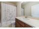 Bright bathroom with white shower curtain, a wood vanity with light countertop, and a modern sink at 5260 Cresslyn Rdg, Alpharetta, GA 30005