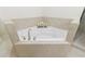 Corner bathtub with tile surround, decorative candles and shower access at 5260 Cresslyn Rdg, Alpharetta, GA 30005