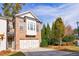 Attractive townhome with a brick facade, two-car garage, and well-maintained lawn, situated in a desirable neighborhood at 5260 Cresslyn Rdg, Alpharetta, GA 30005