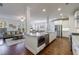 Modern kitchen open to the living area featuring granite countertops, stainless steel appliances, and hardwood floors at 5260 Cresslyn Rdg, Alpharetta, GA 30005