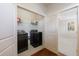 Laundry area with modern washer and dryer, storage shelf, and doorway view to bedroom at 5260 Cresslyn Rdg, Alpharetta, GA 30005