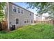 View of the backyard with overgrown grass, a patio, and a fence at 1218 Matt Moore Ct, Lithia Springs, GA 30122