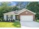 Charming single-story home featuring a brick accent, a well-manicured lawn, and an attached two-car garage at 5527 Jerome Rd, College Park, GA 30349