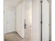 Hallway view featuring neutral walls and carpet leading to doorway and a white paneled door at 5527 Jerome Rd, College Park, GA 30349