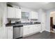 Charming kitchen with white cabinets, stainless steel appliances and new, wood-look flooring at 5527 Jerome Rd, College Park, GA 30349