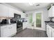 Well-lit kitchen with stainless steel appliances, white cabinets, and a door to the exterior at 5527 Jerome Rd, College Park, GA 30349