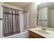 Bathroom featuring a shower-tub combo, shower curtain and a vanity sink with mirror at 1645 Colleens Cask Ter, Dacula, GA 30019