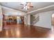 Open floor plan featuring hardwood floors, fireplace, ceiling fan, kitchen access and staircase access at 1645 Colleens Cask Ter, Dacula, GA 30019