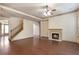 Spacious living room with hardwood floors, fireplace, ceiling fan, and staircase access at 1645 Colleens Cask Ter, Dacula, GA 30019