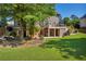 Expansive backyard with lush lawn, mature trees, a stone patio, and wooden deck at 3641 Carriage Glen Way, Dacula, GA 30019