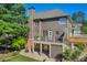 Exterior view of a multi-story home with a deck, stone patio, and a spacious, well-kept lawn at 3641 Carriage Glen Way, Dacula, GA 30019