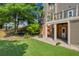 Relaxing backyard featuring a cozy stone patio, spacious lawn, mature trees, and shaded deck at 3641 Carriage Glen Way, Dacula, GA 30019