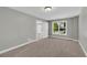 Comfortable bedroom with neutral carpeting, a window view, gray walls, and a closet at 3641 Carriage Glen Way, Dacula, GA 30019