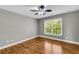 Spacious bedroom with hardwood floors, neutral walls, ceiling fan, and a bright window at 3641 Carriage Glen Way, Dacula, GA 30019