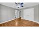 Bedroom featuring hardwood floors, neutral walls, white trim, a ceiling fan, and closet at 3641 Carriage Glen Way, Dacula, GA 30019